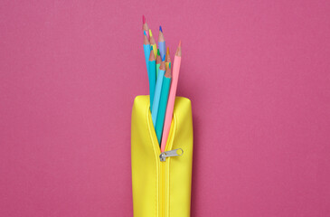 School pencil case with colored pencils on a pink background. Back to school concept