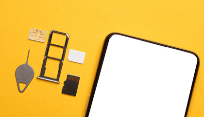 Smartphone with white blank screen, Tray with SIM and micro SD memory cards on a yellow background. Flat lay