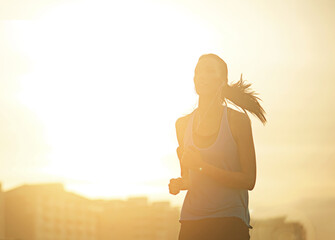 Woman, running and silhouette in sunrise for exercise with mockup space in sky with buildings in...