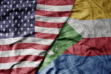 big waving colorful flag of united states of america and national flag of comoros on the dollar money background. finance concept .