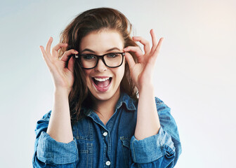 Woman, glasses and eyesight in studio eyesight with smile, excited or wellness with vision by white...