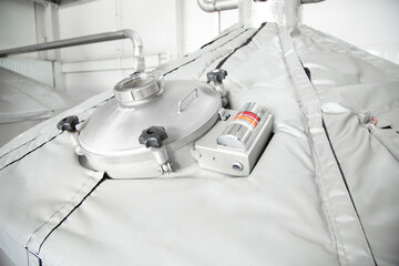   Stainless steel  storage tank in a brewery factory. Sight manhole of brewery equipment . Soft focus