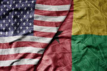 big waving colorful flag of united states of america and national flag of guinea bissau on the dollar money background. finance concept .