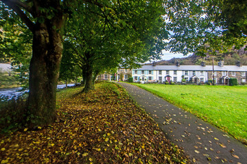 Picturesque leaf scattered path leading towards the Victorian stone houses along the edge of the small Welsh Village of Beddgelert