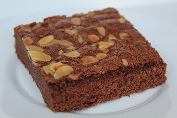 Brownies cake with almond topping, isolated on white background