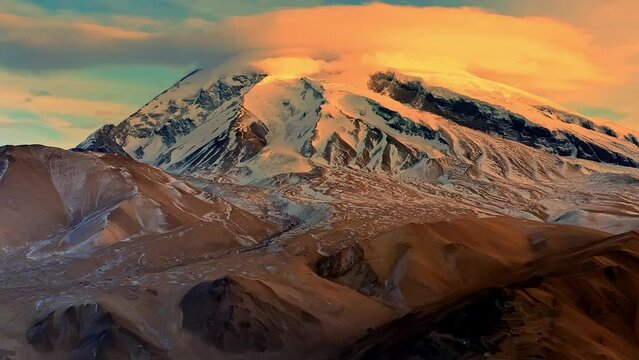 Aerial photo of sunset sunshine mountain and lenticular cloud on Muztagh Ata, Pamir Plateau, Kizilsu Kirgiz Autonomous Prefecture, Xinjiang, China