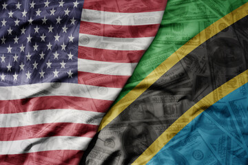 big waving colorful flag of united states of america and national flag of tanzania on the dollar...