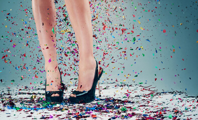 Woman, legs and heels with confetti for celebration of new years, party and decoration for event....