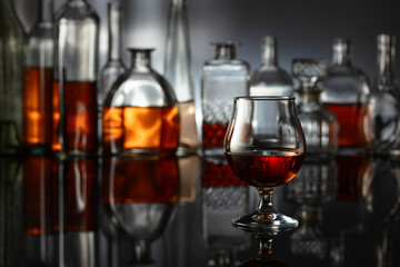 Snifter of brandy on a black reflective background.
