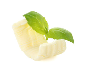 One tasty butter curl and basil leaves isolated on white