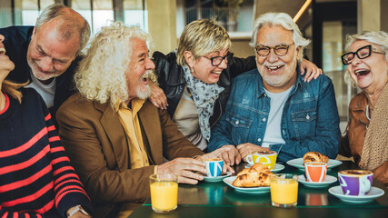 Happy senior people having breakfast sitting at coffee bar - Group of older friends having fun in...