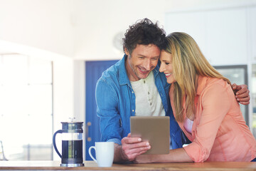 Mature, couple and smile in kitchen with tablet for reading online post, social media scroll or embrace in home. People, hug or laughing with tech app for funny meme, bonding or morning news in house