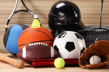 Many different sports equipment on wooden table