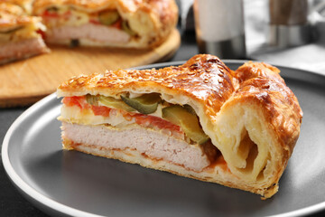 Piece of tasty homemade pie with filling on dark grey table, closeup