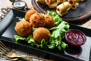 Deep fried cheese balls breaded and deep fried with berries sauce on rustic background. Appetizer...