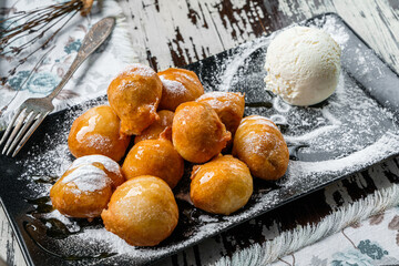 Fried donuts with syrup and ice cream on wooden background. Sweets, dessert and pastry, top view