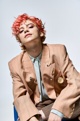 Extraordinary woman with vibrant red hair sitting on a chair.