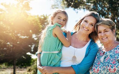 Fototapeta premium Portrait, grandmother and mama with girl, outdoor and happiness with hug, sunshine and bonding together. Face, family in park or parent with daughter, summer and relax with vacation, love or cheerful