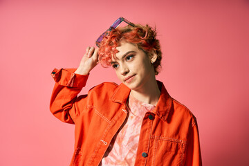 A woman with red hair wearing an orange jacket.