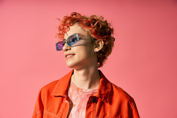 A captivating woman with red hair and sunglasses exudes confidence and style.