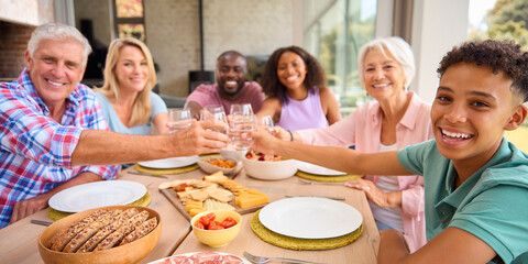 Portrait Of Three Generation Family Indoors At Home Doing Cheers With Water Before Eating Meal 