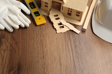 Building level and other construction tools on wooden table, above view. Space for text