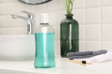 Bottle of mouthwash on white table in bathroom