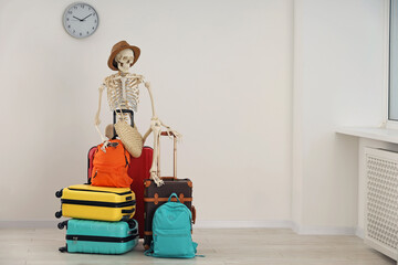 Waiting concept. Human skeleton in hat with suitcases indoors, space for text