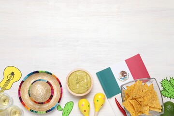 Mexican flag, maracas, tequila, nachos chips and sombrero hat on white wooden table, flat lay....