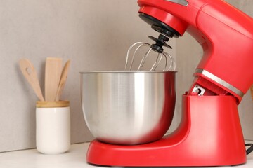 Modern red stand mixer on white table in kitchen, closeup