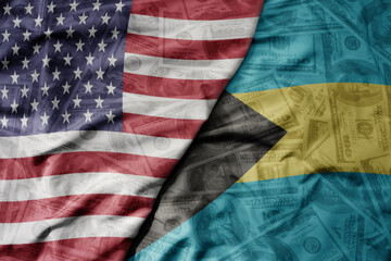 big waving colorful flag of united states of america and national flag of bahamas on the dollar...