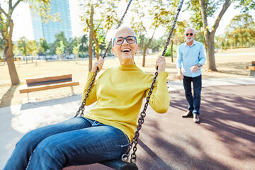 woman man outdoor senior couple happy swing swinging fun leisure retirement together love elderly...