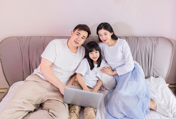 Fototapeta premium A family of three in the bed in the bedroom