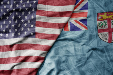 Fototapeta premium big waving colorful flag of united states of america and national flag of Fiji on the dollar money background. finance concept.