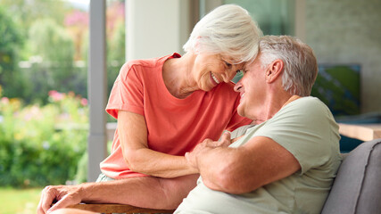 Head And Shoulders Of Loving Senior Couple On Hugging Indoors At Home Together