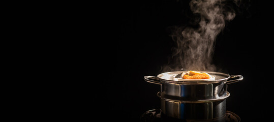 A boiling pot steams up as a chef cooking steam food in steam pot in a restaurant.	