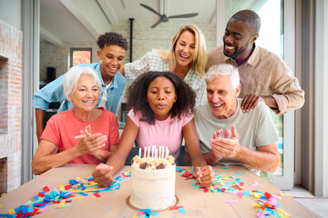 Three Generation Family Indoors At Home Celebrating Teenage Daughter's Birthday With Party And Cake