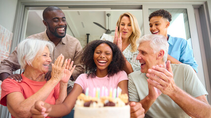 Three Generation Family Indoors At Home Celebrating Teenage Daughter's Birthday With Party And Cake