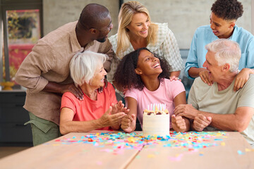 Three Generation Family Indoors At Home Celebrating Teenage Daughter's Birthday With Party And Cake