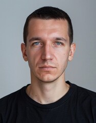 Fototapeta premium ID Photo for Passport : European adult man with straight short black hair and blue eyes, clean-shaven, without glasses and wearing a black t-shirt