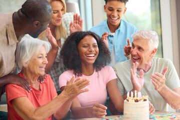 Three Generation Family Indoors At Home Celebrating Teenage Daughter's Birthday With Party And Cake