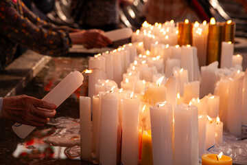 Lighting the candles for the wishes in the Buddhist temple