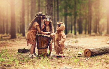 Native American children, drum and happy for music with playing, bonding and connection in woods. Siblings, kids and instruments with culture, heritage and history in forest with family in California