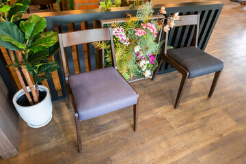 Wooden chairs and tables with green forest wall,flower and red brick wall in Relax restaurant or cafe.