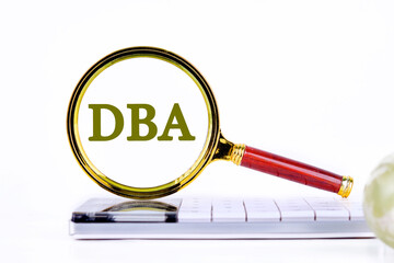 DataBase Administrator or doing business as abbreviation. DBA concept, DBA inscription was found using a magnifying glass on the calculator. Concept photo