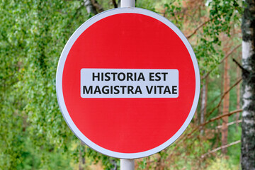 Historia est vitae magistra (History is the tutor of life) Latin phrase on the road sign in front of the forest