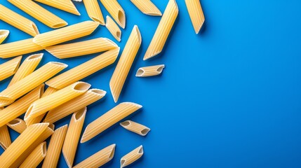   A blue backdrop displays an assembly of intact and several cut-out uncooked pasta pieces - Powered by Adobe