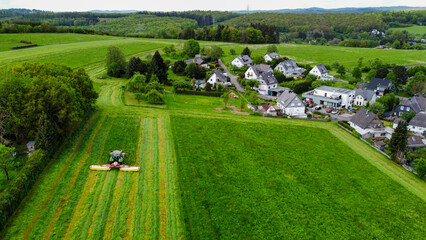 Ein Landwirt m&auml;ht mit Traktor eine Wiese (Luftaufnahme)