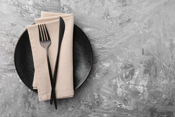 Elegant setting with stylish cutlery on grey textured table, top view. Space for text