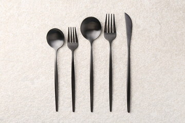 Stylish cutlery set on beige textured table, flat lay